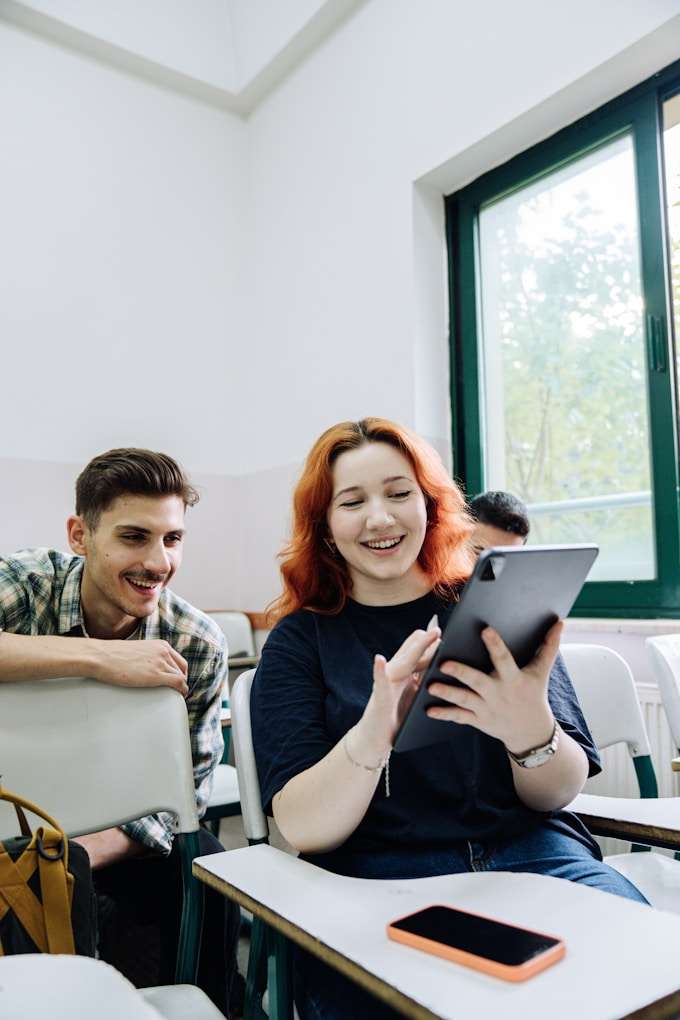 Une femme montre l'écran d'une tablette numérique à un homme